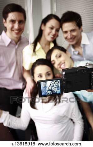 Stock Photo - Office colleagues photographing at party with pregnant colleague. Fotosearch