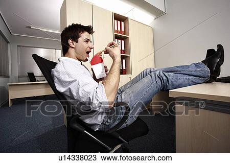 Office worker eating Chinese food at desk View Large Photo Image Stock Image - Office worker eating Chinese food at desk. Fotosearch
