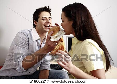 Office worker feeding his colleague at desk View Large Photo Image Stock Photo - Office worker feeding his colleague at desk. Fotosearch