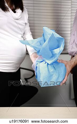Pregnant office worker receiving a present View Large Photo Image Stock Image - Pregnant office worker receiving a present. Fotosearch