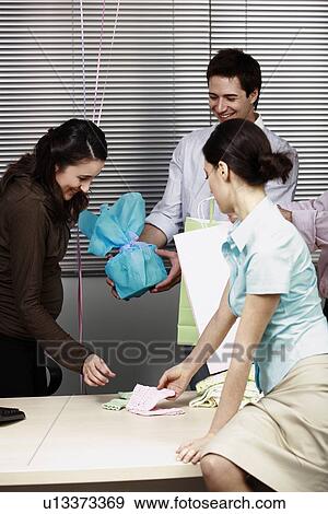 Pregnant office worker receiving presents at party View Large Photo Image Stock Photo - Pregnant office worker receiving presents at party. Fotosearch