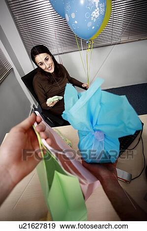 Stock Photo - Pregnant office worker receiving presents at party. Fotosearch