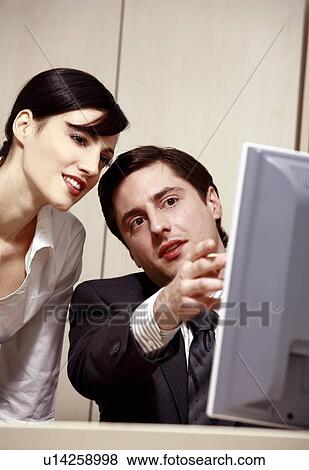 Stock Photo - Businessman and woman at computer. Fotosearch
