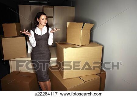 Stock Photo - Businesswoman among boxes. Fotosearch