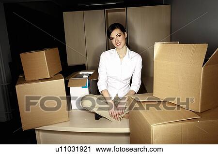 Businesswoman on desk among boxes View Large Photo Image Stock Image - Businesswoman on desk among boxes. Fotosearch