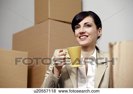 Businesswoman with coffee cup among boxes View Large Photo Image Stock Photo - Businesswoman with coffee cup among boxes. Fotosearch
