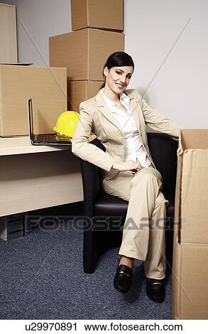 Businesswoman with laptop among boxes View Large Photo Image Stock Image - Businesswoman with laptop among boxes. Fotosearch