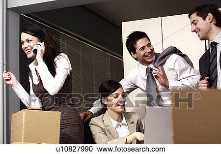 Stock Image - Four business people at laptop in office. Fotosearch