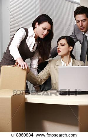 Picture - Three business people at laptop in office. Fotosearch
