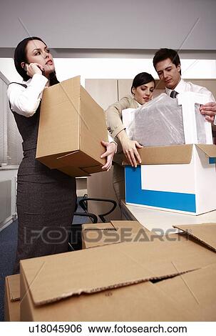 Three business people unpacking boxes in office View Large Photo Image Stock Photograph - Three business people unpacking boxes in office. Fotosearch