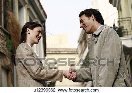 Stock Image - Businessman and woman shaking hands. Fotosearch