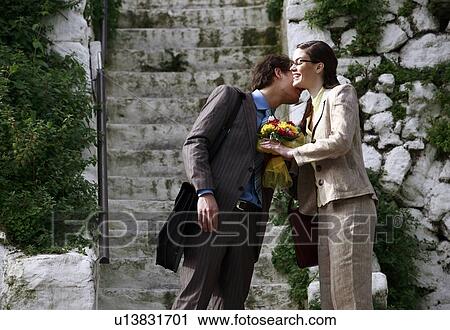 Stock Image - Businessman giving businesswoman flowers. Fotosearch