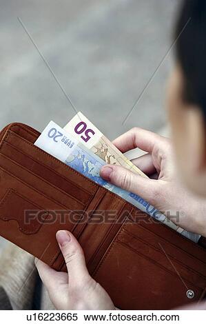 Stock Photography - Closeup of hands holding wallet with euros. Fotosearch