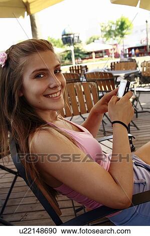 Stock Image - Female teenager with cell phone. Fotosearch