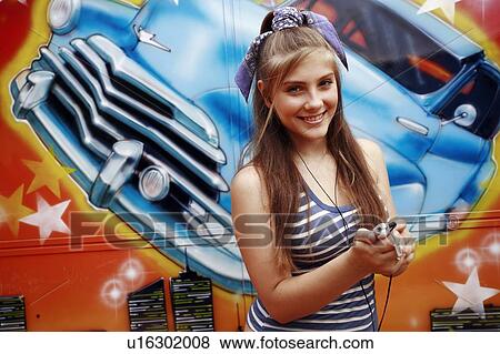 Female teenager with mp3 player in front of graffiti View Large Photo Image Stock Photo - Female teenager with mp3 player in front of graffiti. Fotosearch