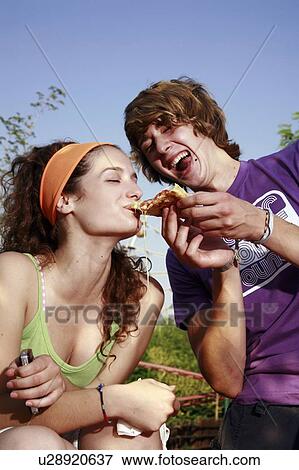 Male teenager feeding female teenager pizza View Large Photo Image Stock Photo - Male teenager feeding female teenager pizza. Fotosearch