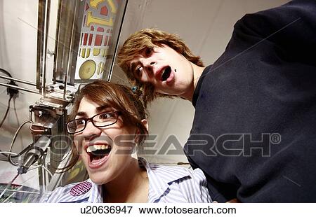 Stock Photo - Teenage couple at game in arcade. Fotosearch