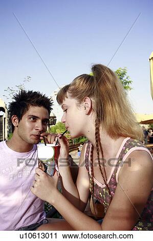 Teenage couple sharing a soda View Large Photo Image Stock Image - Teenage couple sharing a soda. Fotosearch