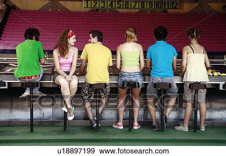 Stock Photo - Teenagers at game in amusement park. Fotosearch