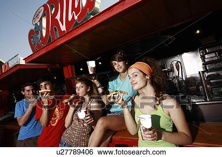 Stock Photograph - Teenagers hanging out, eating pizza. Fotosearch