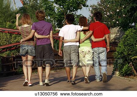 Stock Photograph - Teenagers taking a walk in amusement park. Fotosearch