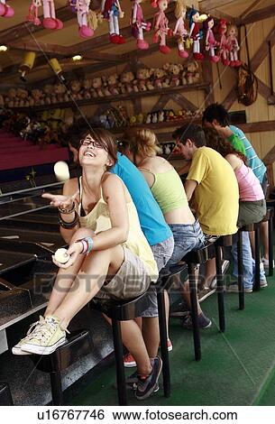 Stock Photograph - Female teenager playing ball at game in amusement park. Fotosearch