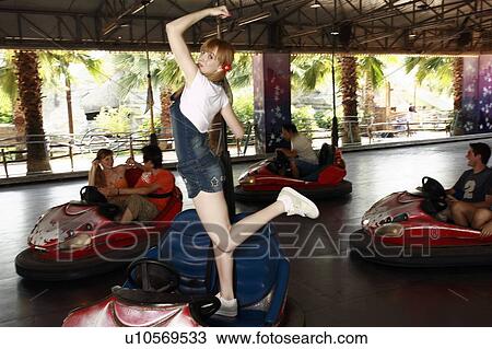 Stock Image - Female teenager posing on bumper car. Fotosearch