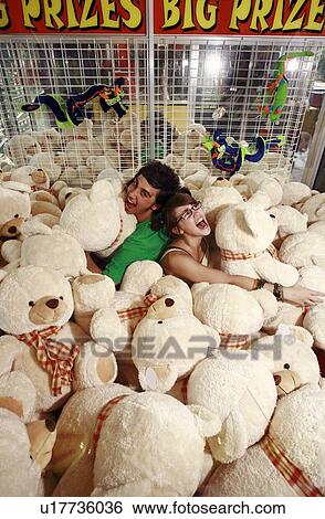 Teenage couple among teddy bears in arcade View Large Photo Image Stock Photograph - Teenage couple among teddy bears in arcade. Fotosearch