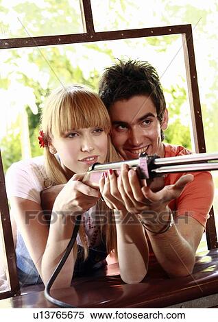 Teenage couple at shooting game in amusement park View Large Photo Image Stock Photography - Teenage couple at shooting game in amusement park. Fotosearch