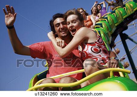 Stock Image - Teenage couple on amusement park ride. Fotosearch
