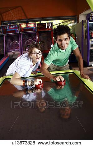 Teenage couple playing game in arcade View Large Photo Image Stock Photo - Teenage couple playing game in arcade. Fotosearch