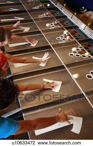 Stock Image - Teenagers playing game in amusement park. Fotosearch