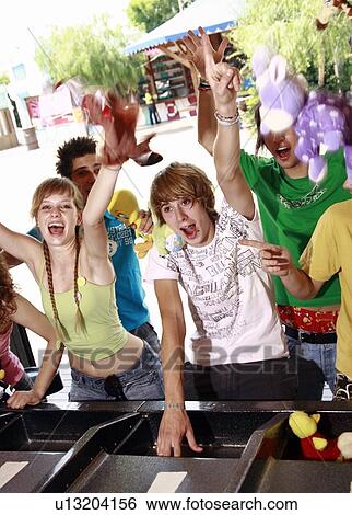 Teenagers playing game in amusement park View Large Photo Image Stock Photograph - Teenagers playing game in amusement park. Fotosearch
