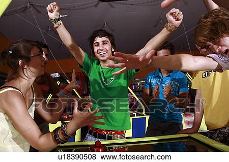 Teenagers playing game in arcade View Large Photo Image Stock Photo - Teenagers playing game in arcade. Fotosearch