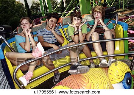 Stock Image - Teenagers posing on amusement park ride. Fotosearch