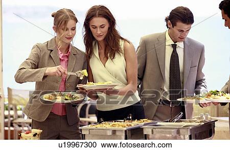 Stock Image - Business people at lunch buffet. Fotosearch