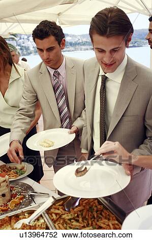 Stock Image - Businessmen at lunch buffet. Fotosearch