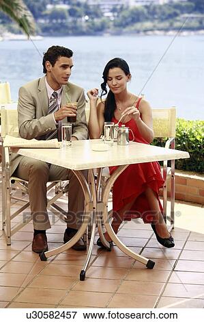 Couple at seaside cafe table View Large Photo Image Stock Photo - Couple at seaside cafe table. Fotosearch