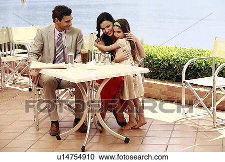 Couple with daughter at seaside cafe table View Large Photo Image Stock Image - Couple with daughter at seaside cafe table. Fotosearch