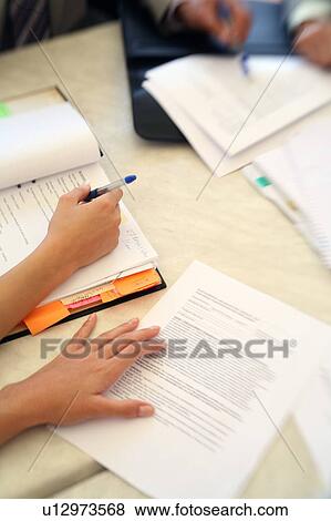Documents and hands at a table View Large Photo Image Stock Photo - Documents and hands at a table. Fotosearch