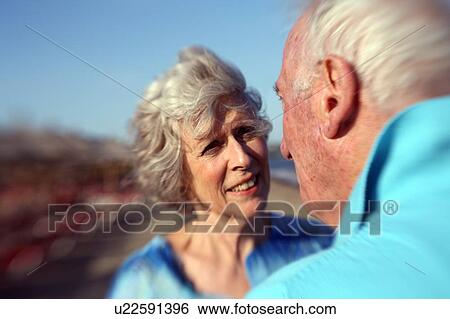 Stock Photograph - Closeup of senior couple on the beach. Fotosearch