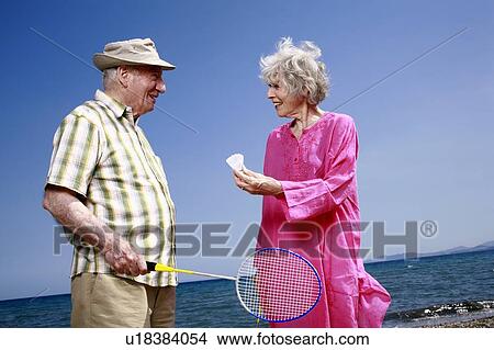 Senior couple on beach with badminton racquet and ball View Large Photo Image Picture - Senior couple on beach with badminton racquet and ball. Fotosearch