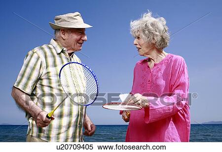 Senior couple on beach with badminton racquets and ball View Large Photo Image Stock Photography - Senior couple on beach with badminton racquets and ball. Fotosearch