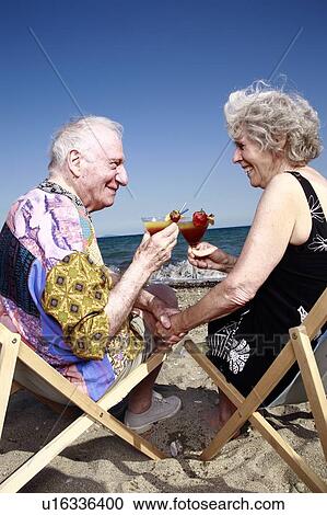 Senior couple with cocktails on beach View Large Photo Image Stock Image - Senior couple with cocktails on beach. Fotosearch