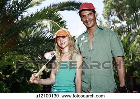 Stock Image - Father and daughter with baseball outfit. Fotosearch
