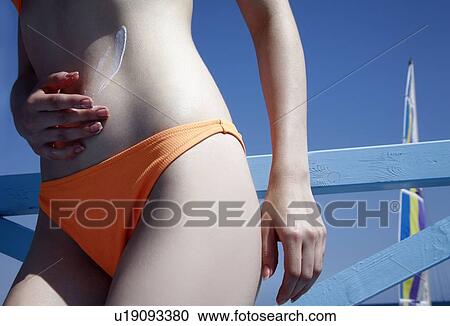 Female young adult applying suntan lotion View Large Photo Image Stock Image - Female young adult applying suntan lotion. Fotosearch