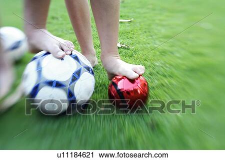 Stock Image - Two children's legs with balls. Fotosearch