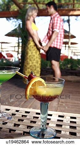Cocktails with mature adult couple in background View Large Photo Image Picture - Cocktails with mature adult couple in background. Fotosearch