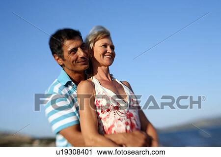 Stock Image - Mature adult couple on beach. Fotosearch