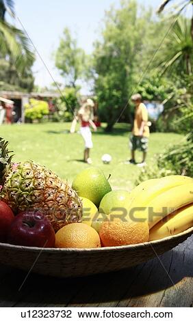 Bowl of fruit with boy and girl playing ball View Large Photo Image Stock Image - Bowl of fruit with boy and girl playing ball. Fotosearch